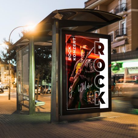 Plakat an einer Haltestelle mit dem Wort "ROCK" und einem Musiker mit einer Gitarre.